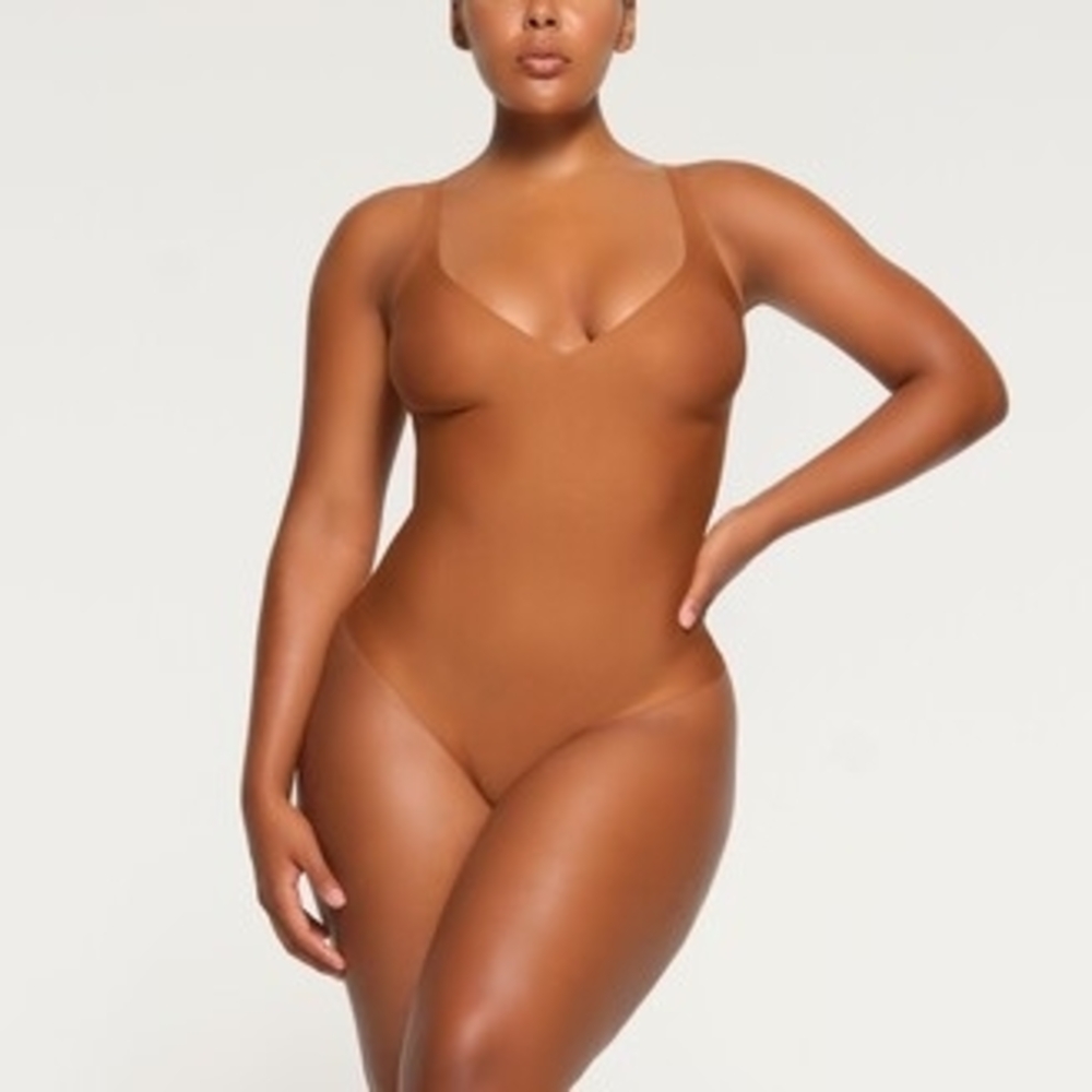 SKIMS BODY UNLINED PLUNGE THONG BODYSUIT | bronze